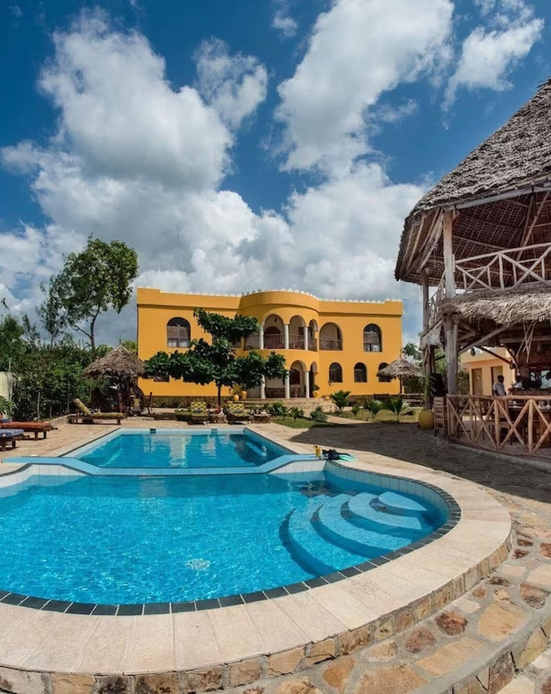 The hotel pool and main building surrounded by palms