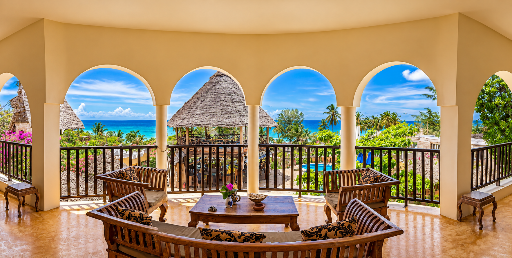 Arched terrace with lounge seating overlooking tropical grounds and the ocean