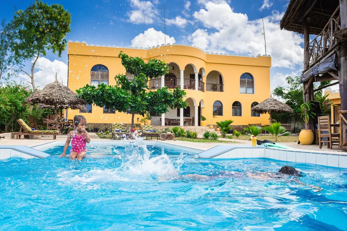 Child splashing in the hotel pool in front of the villa